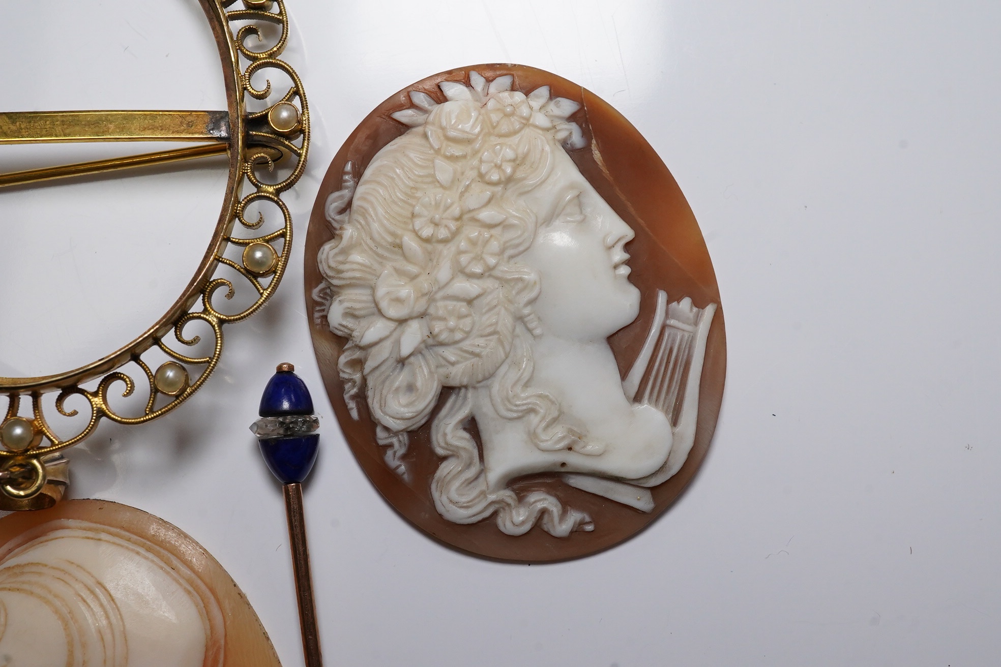 Three carved oval cameo shells, including tow in 9ct pendant or brooch mount, a 9ct gold wrist watch (a.f.) and a stick pin. Condition - poor to fair